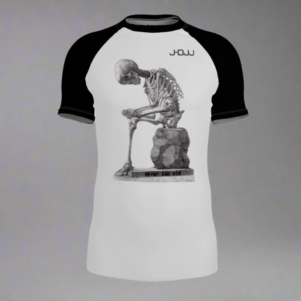 White and black jiu jitsu rash guard with skeleton design and 'J-BJJ' branding on a white background