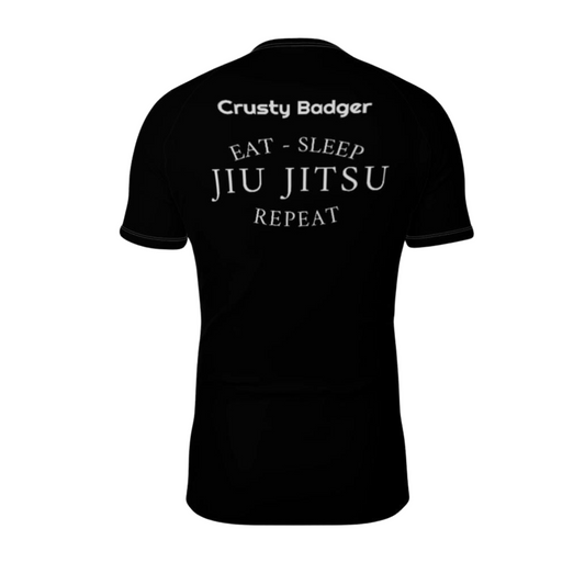 Black rash guard rear with 'Crusty Badger' and 'Eat - Sleep Jiu Jitsu Repeat' text on a white background