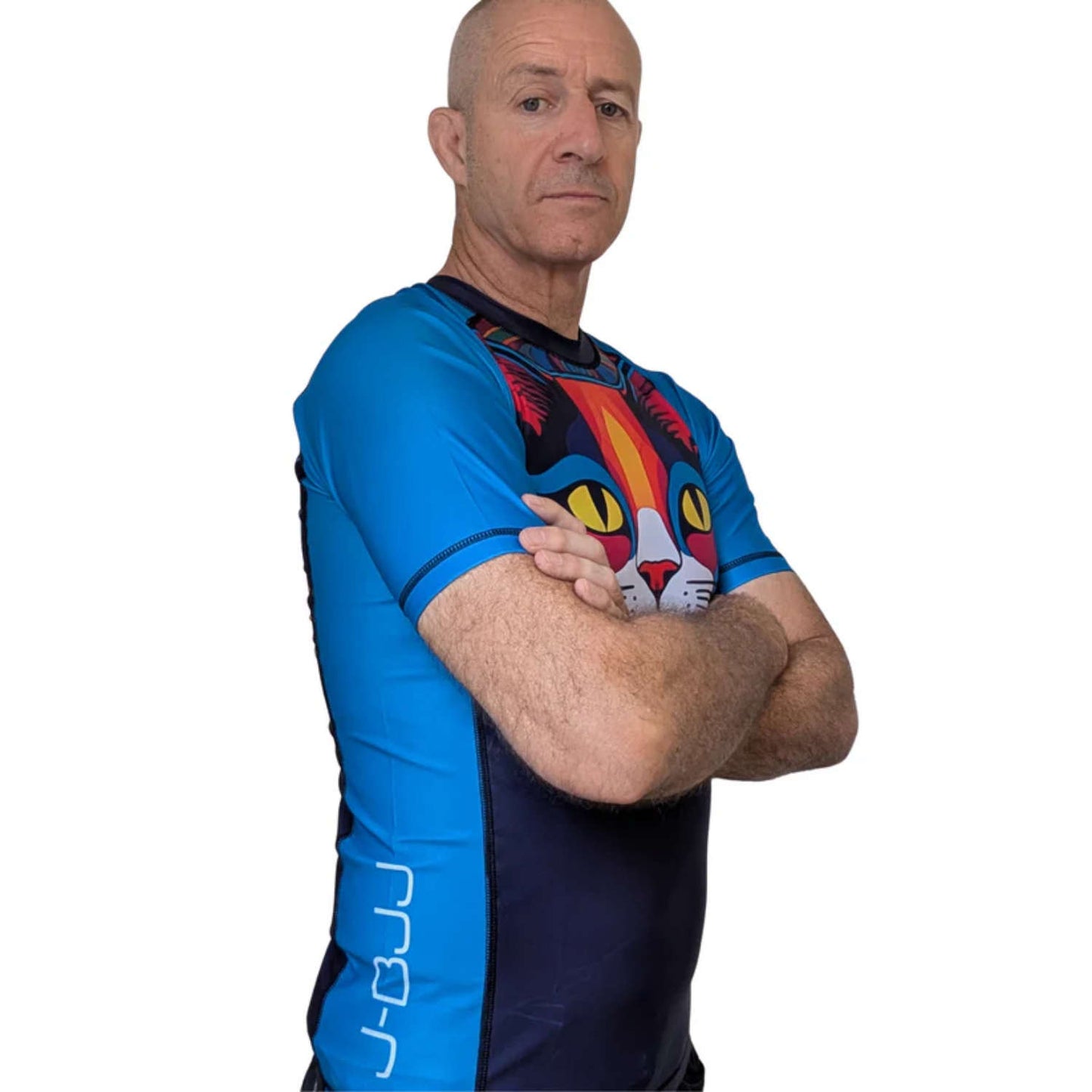 Man wearing a blue and black BJJ rash guard. Colorful cat design. White background