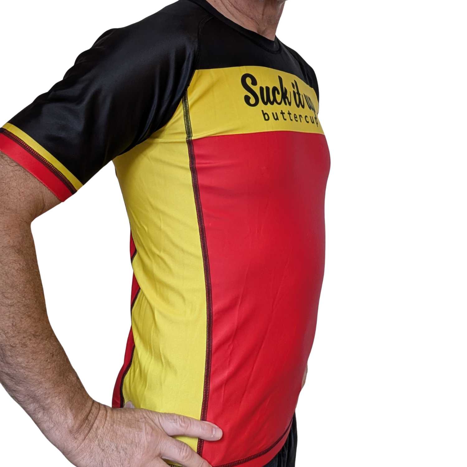 Person wearing a black, yellow, and red BJJ rash guard with text on a white background